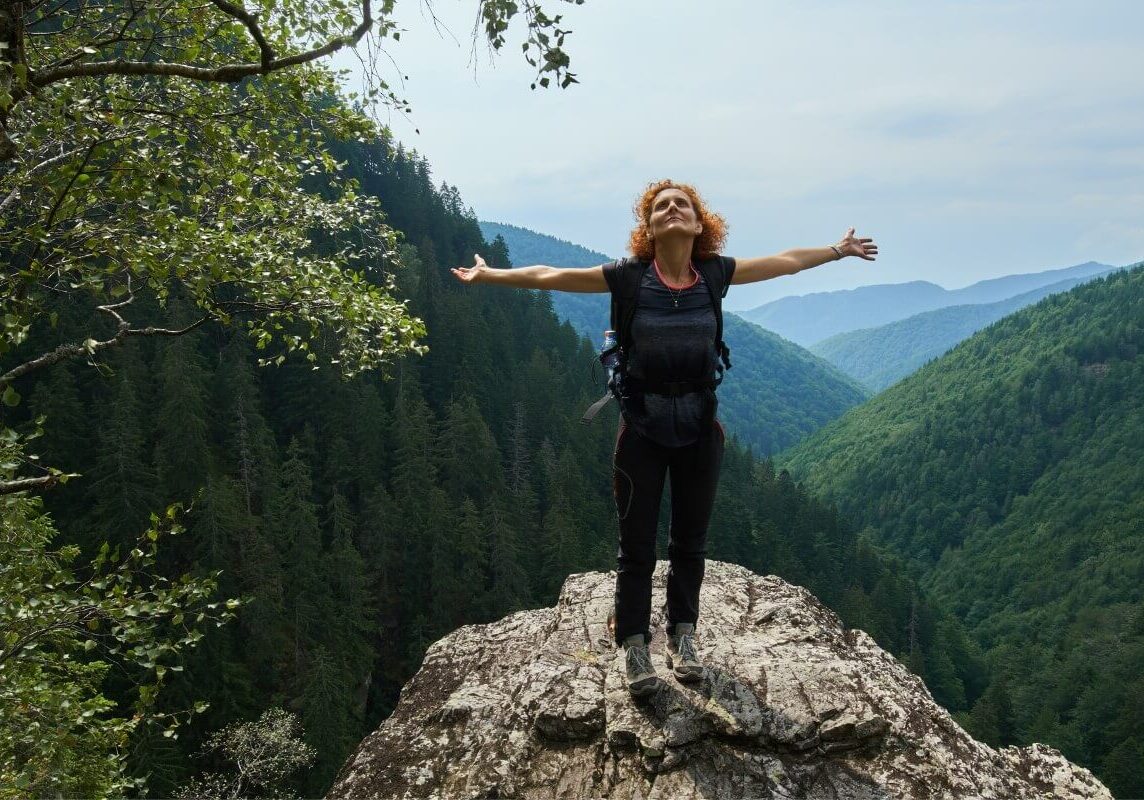Woman Standing at the top of the mountain