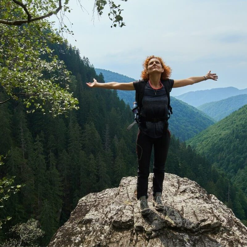 Woman Standing at the top of the mountain